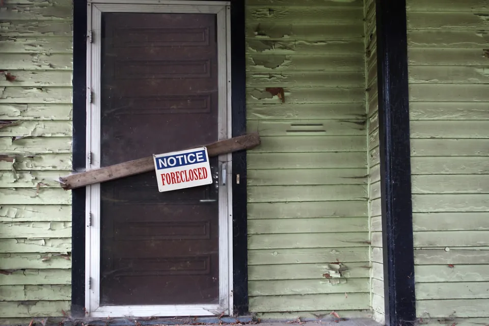Vacant home with foreclosure sign.